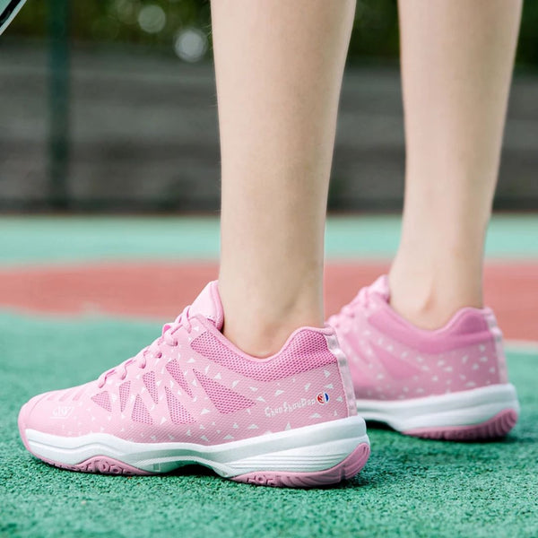 Roze tennisschoenen op tennisbaan, sportieve dames sneakers, ademend mesh, comfortabele pasvorm, geschikt voor buitenactiviteiten, sportmode.
