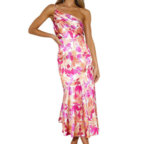 Vrouw in elegante, asymmetrische bloemenjurk met roze en oranje tinten, ideaal voor zomermode en speciale gelegenheden.