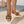 Dames sleehaksandalen met bruine leren bandjes en zilveren ringdetail, op een gevlochten jute zool. Perfect voor zomerse mode en casual outfits.