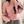 Vrouw in roze trui met zwarte strikdetails, casual mode, comfortabele kleding, trendy dameskleding, herfstoutfit, modieuze sweaterstijl.