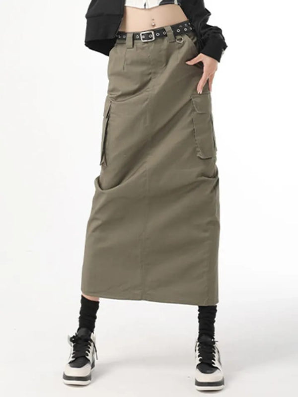 Lange groene cargorok met zakken, zwarte riem en sneakers. Trendy streetwear mode voor dames. Comfortabele en stijlvolle outfit.