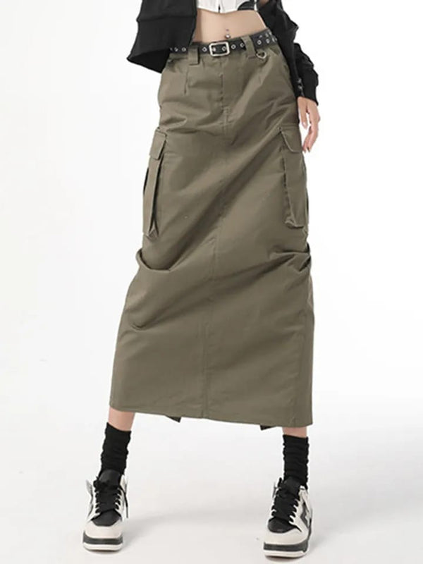 Olijfgroene cargorok met zakken, zwarte riem en hoge taille, gecombineerd met zwarte sneakers. Trendy streetwear mode voor dames.