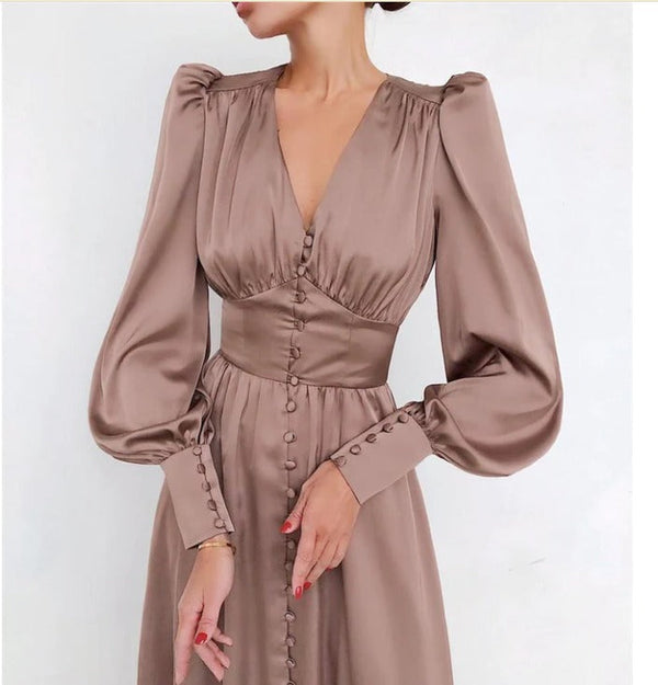 Vrouw in elegante, zijden bruine jurk met lange pofmouwen en knoopsluiting, modieuze kleding, stijlvolle damesmode, vintage uitstraling.