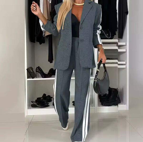 Grijze damespak met witte strepen, zwarte top en handtas, stijlvolle outfit voor kantoor of casual, mode 2024, kledingkast op achtergrond.