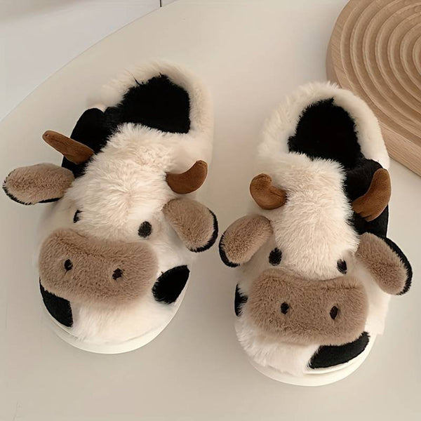 Pluche koeienpantoffels voor volwassenen, zwart-wit design met bruine hoorns, comfortabele warme sloffen, perfect voor winterse dagen thuis.
