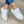 Witte dames sneakers met gouden details en ketting, gedragen met blauwe jeans. Stijlvolle casual schoenen voor dagelijks gebruik.