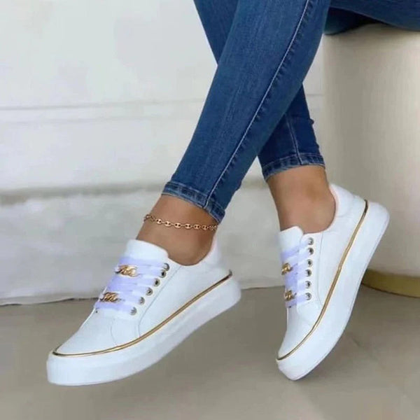 Witte dames sneakers met gouden details, gedragen met blauwe jeans. Stijlvolle casual schoenen, perfect voor dagelijks gebruik en modebewuste outfits.
