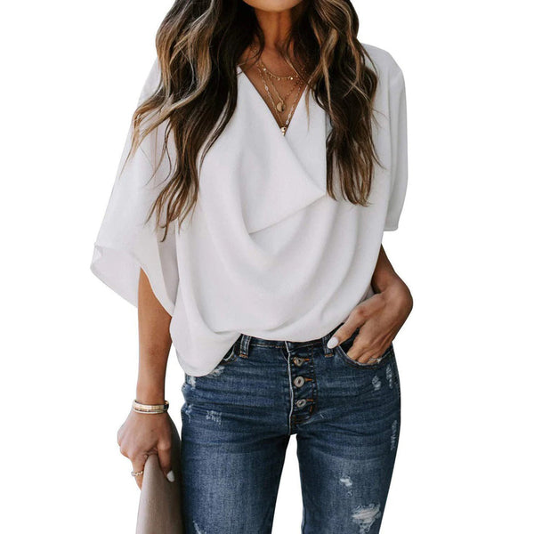 Vrouw in witte blouse met draperie, gecombineerd met blauwe jeans. Modieuze casual outfit, ideaal voor dameskleding en trendy stijlen.