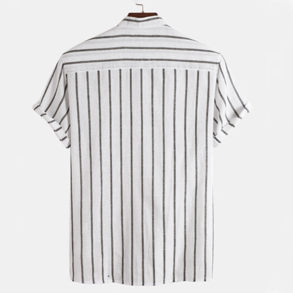 Wit overhemd met zwarte verticale strepen, korte mouwen en opgevouwen manchetten, hangend aan een houten hanger. Perfect voor casual en zakelijke looks.