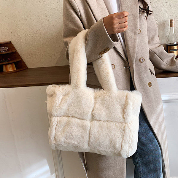 Vrouw met stijlvolle witte pluchen tas, winterjas en jeans. Modieuze handtas, zachte textuur, trendy accessoire voor koude seizoenen.