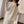 Vrouw draagt beige wintervest, mouwloos en van fleece, ideaal voor koude seizoenen. Stijlvolle damesmode, comfortabele en warme outfit.