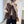Vrouw draagt bruine fleece gilet, wintermode, casual stijl, met knopen en zakken, gecombineerd met beige trui en zwarte broek, trendy dameskleding.
