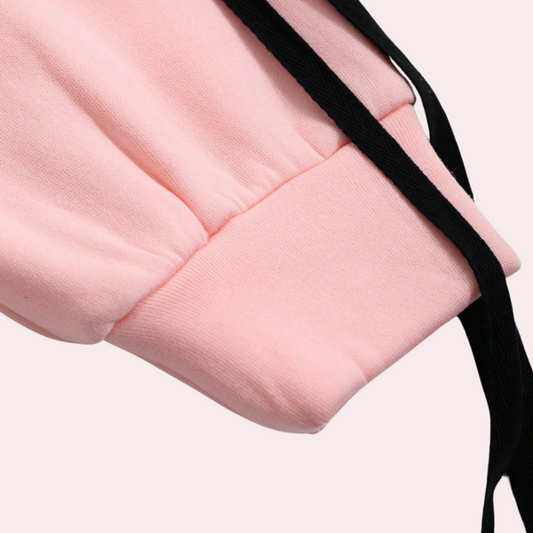 Roze sweatshirt mouw met zwarte trekkoorden, close-up. Comfortabele katoenen stof, casual mode, trendy streetwear.