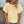 Vrouw in gele geperforeerde blouse, casual zomeroutfit, modieuze kleding, trendy damesmode, buiten bij muur, golvend haar, kettingaccessoire.