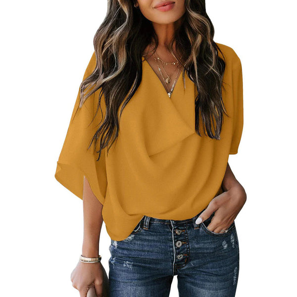 Vrouw in gele blouse met vleermuismouwen en V-hals, gecombineerd met blauwe jeans. Modieuze dameskleding, casual stijl, trendy outfit.