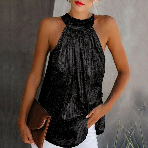 Vrouw in zwarte, mouwloze haltertop met glinsterende textuur, witte broek en bruine clutch. Stijlvolle zomermode, elegante avondlook.