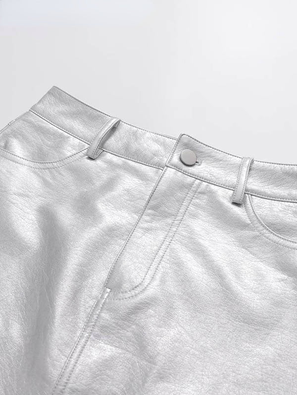 Zilveren leren rok met knoopsluiting en riemlussen, glanzende metallic afwerking, modieuze dameskleding, perfect voor feestelijke gelegenheden.