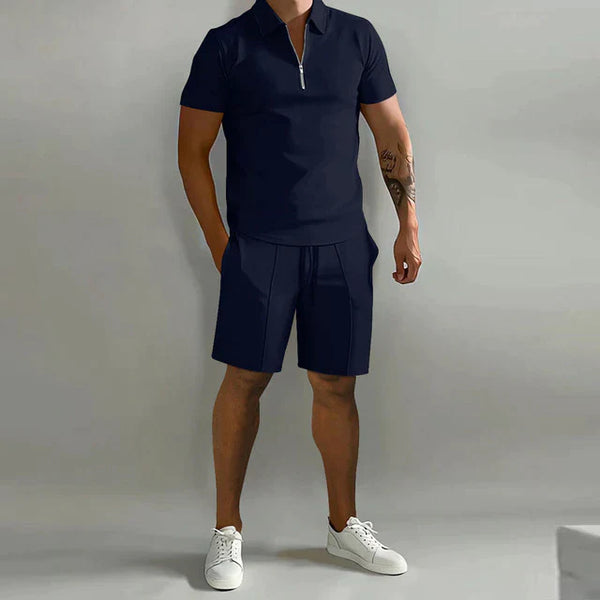 Donkerblauw heren trainingspak met korte mouwen poloshirt en sportshorts, ideaal voor zomer, casual en sportieve outfits.