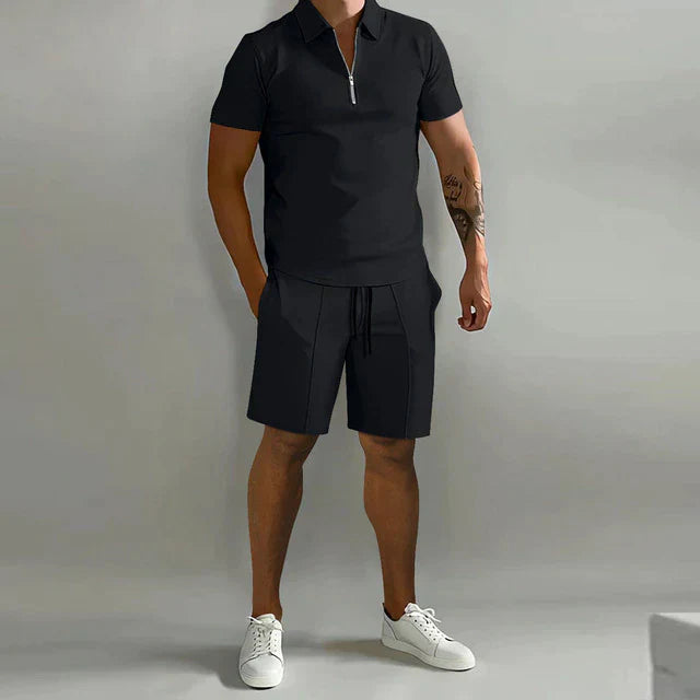 Zwarte heren poloshirt en korte broek set, sportief en casual, ideaal voor zomertraining. Comfortabele pasvorm, korte mouwen, met rits.