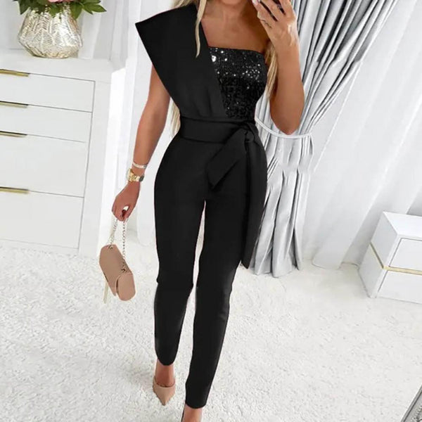Elegante zwarte jumpsuit met pailletten top en strikceintuur, perfect voor avondkleding. Stijlvolle damesmode, ideaal voor feestelijke gelegenheden.