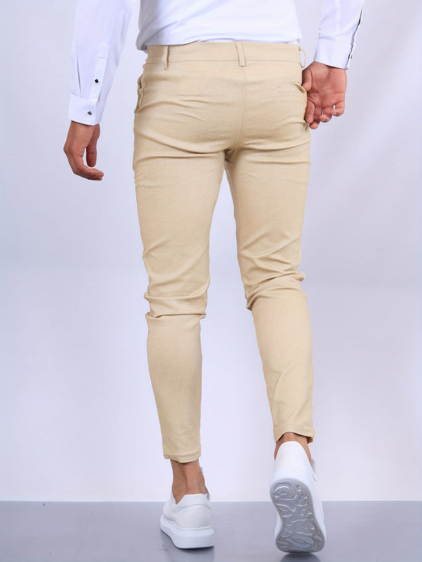 Man in beige chino broek en witte sneakers, gezien van achteren. Stijlvolle casual outfit, perfect voor moderne herenmode en dagelijkse looks.