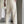 Man in moderne, crèmekleurige broek met zwarte schoenen, draagt witte papieren tas. Stijlvolle herenkleding, minimalistisch design, modeaccessoires.