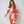 Vrouw in kleurrijke, geometrische jurk met lange mouwen, rood, wit en bruin patroon. Modieuze outfit, trendy dameskleding, elegant design.