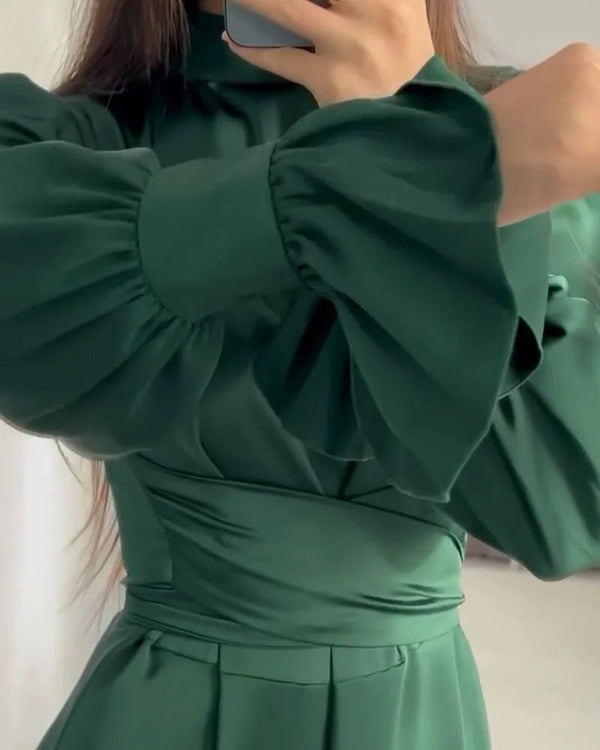 Groene satijnen jurk met lange pofmouwen, elegante tailleband en hoge halslijn. Perfect voor formele gelegenheden en modieuze evenementen.
