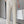 Man in beige pantalon met hoge taille en plooien, draagt een witte papieren tas. Stijlvolle herenkleding, moderne mode, zakelijke outfit.