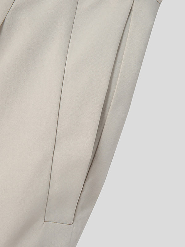 Beige broek met plooien, close-up van de stof en naad, minimalistisch ontwerp, modieuze dameskleding, hoogwaardige materialen.