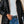 Vrouw in zwarte gewatteerde jas, witte coltrui en blauwe jeans. Wintermode, stijlvolle dameskleding, casual outfit voor koud weer.