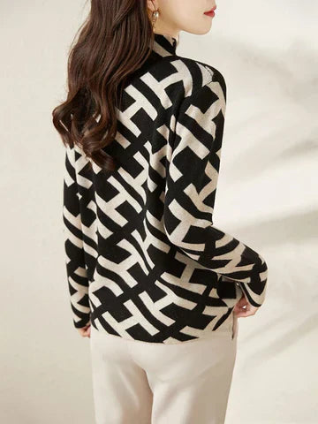 Damestrui met zwart-wit geometrisch patroon, lange mouwen, gedragen door model met bruin haar. Stijlvolle wintermode, trendy dameskleding.