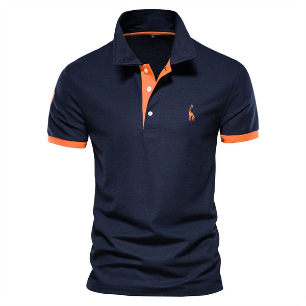 Donkerblauw poloshirt met oranje accenten en geborduurd logo, korte mouwen, katoenen stof. Stijlvol herenmode, casual kleding.