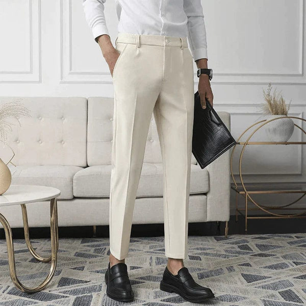 Elegante beige stoffen broek voor heren, gecombineerd met zwarte leren schoenen en een witte blouse. Perfect voor formele en zakelijke gelegenheden.