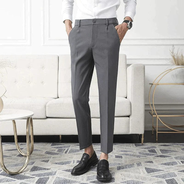 Donkergrijze elegante herenbroek van stof, gedragen door een man in een witte blouse. Perfect voor formele gelegenheden. Stijlvolle herenkleding.