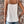 Vrouw in witte kanten top en denim shorts tegen bakstenen muur, zomermode, casual outfit, trendy kleding, dameskleding, boho-stijl.