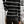 Vrouw in zwart-wit gestreepte coltrui en zwarte leren broek, staand in moderne woonkamer. Stijlvolle wintermode, casual chique outfit.