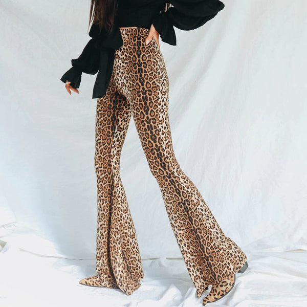 Vrouw in luipaardprint flared broek en zwarte blouse, modetrend, stijlvolle dameskleding, retro look, comfortabele pasvorm, casual outfit.