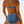 Vrouw in blauwe retro bikini met zigzagpatroon op strand. Hoge taille, halternek. Zomer, strandmode, damesbadkleding, trendy zwemkleding.