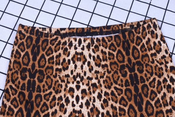 Luipaardprint rok op zwart-wit geruit oppervlak, modetrend, dierenprint kleding, stijlvolle damesmode, trendy rokontwerp.