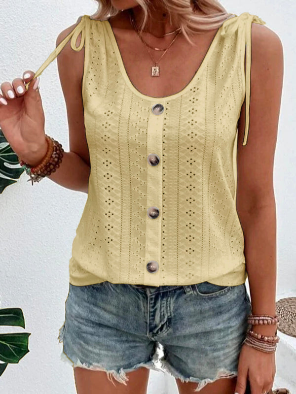 Vrouw in gele mouwloze top met knopen en kanten details, gecombineerd met denim shorts. Zomerse mode, casual outfit, trendy dameskleding.