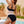 Vrouw in zwarte retro bikini met hoge taille bij zwembad, zomermode, strandkleding, tropische achtergrond, trendy badmode.