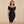 Vrouw in elegante zwarte off-shoulder bodycon jurk, knielengte, met V-hals. Perfect voor feestjes en clubs. Stijlvolle en verfijnde uitstraling.