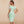 Vrouw in mintgroene off-shoulder bodycon jurk, elegante knielengte, geschikt voor zomerfeesten en clubs. Trendy mode voor dames.