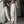 Vrouw in beige wijde broek met zwarte strepen, crop top en pet poseert voor spiegel. Trendy streetwear mode, casual outfit, moderne stijl.