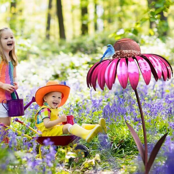 Roze bloemvormige vogelvoeder in tuin met blauwe vogel, omringd door kinderen in kleurrijke kleding. Perfect voor tuinieren en natuurbeleving.
