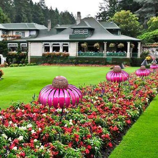 Roze vogelvoederhuisjes in bloementuin voor groot huis, decoratieve tuinaccessoires, buiteninrichting, kleurrijke tuinornamenten.