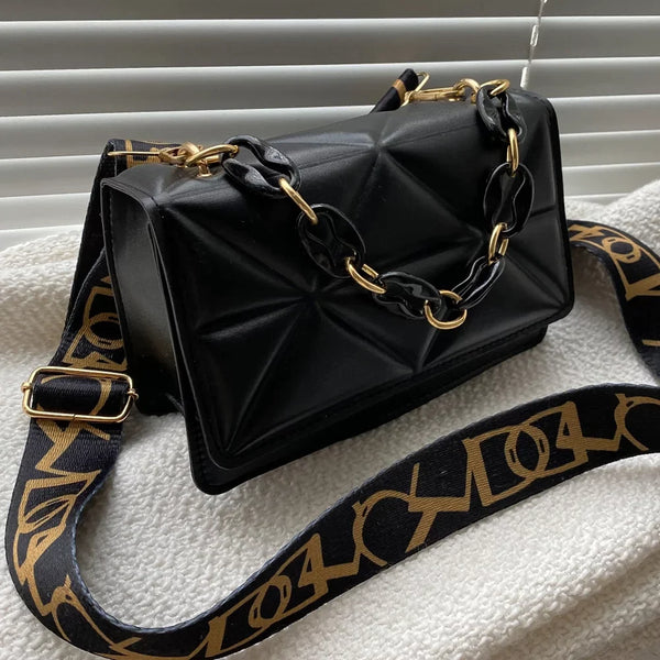 Zwarte leren handtas met gouden ketting en verstelbare schouderriem, luxe design, perfect voor modebewuste vrouwen, stijlvolle accessoire.