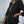 Vrouw in zwarte blazer met opgerolde mouwen, witte blouse en jeans. Stijlvolle zakelijke outfit, mode voor kantoor en casual gelegenheden.