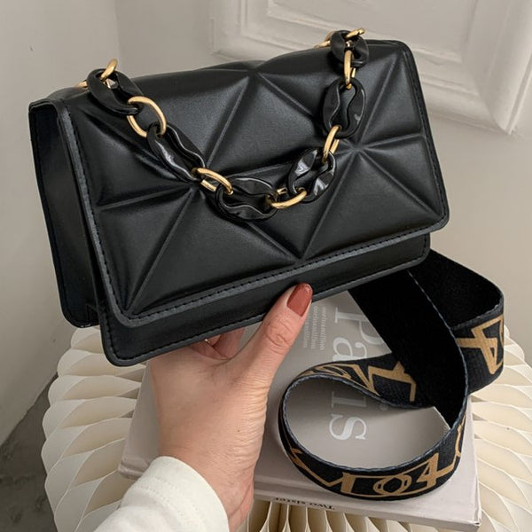 Zwarte leren handtas met geometrisch patroon en goudkleurige kettingriem, stijlvolle modeaccessoire, perfect voor dames, luxe uitstraling.